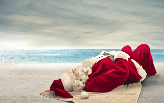 Santa Claus sunbathing lying on the beach